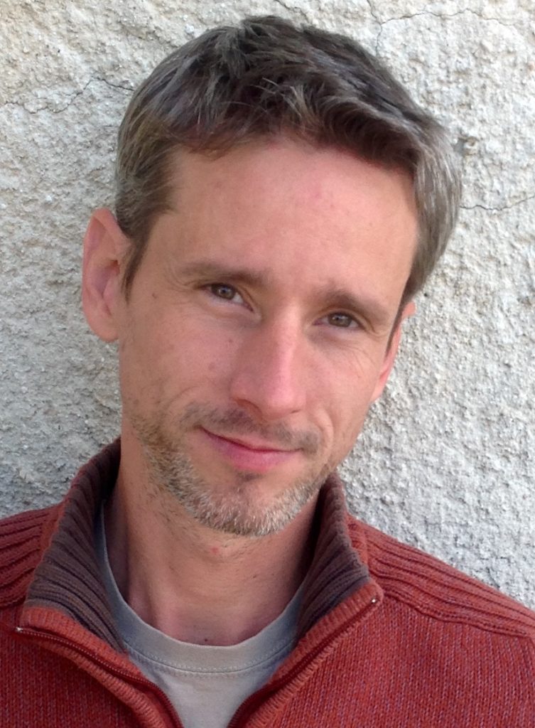 Dániel Váczi portréja, mosolygós arccal, szürke hajjal.