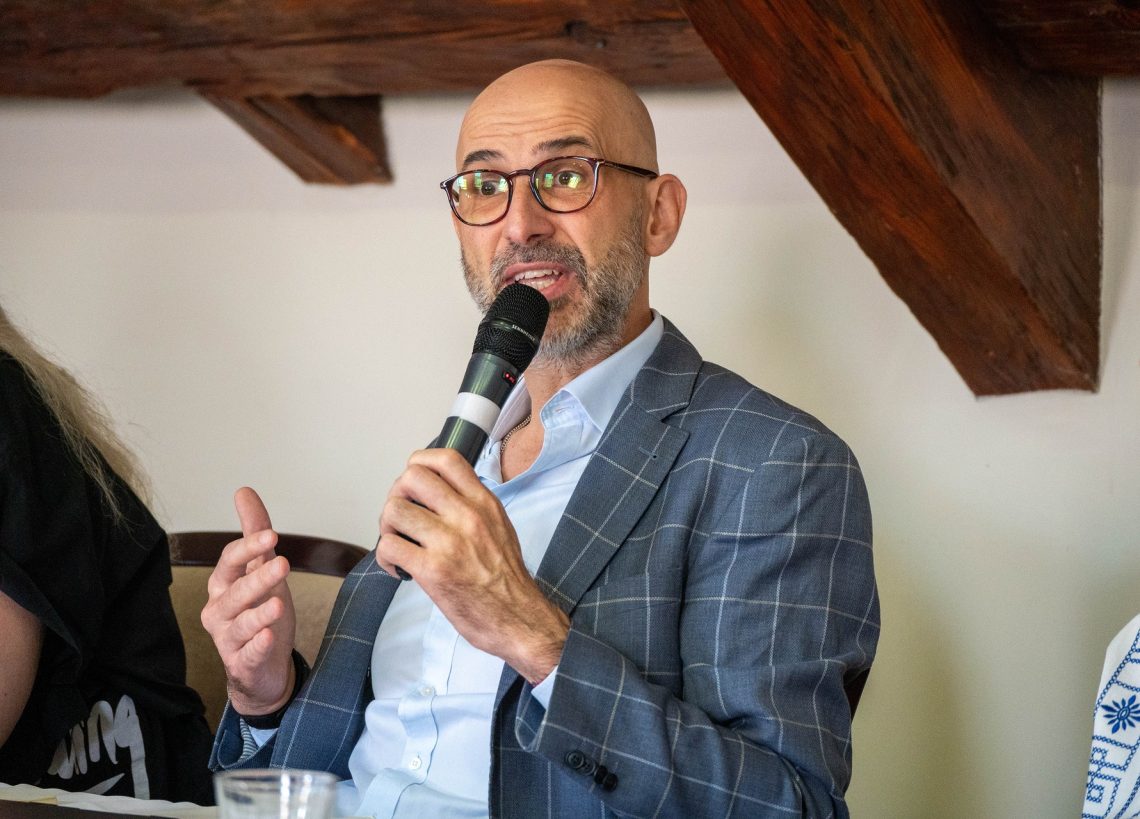 Férfi beszél a mikrofonba a 30. Nemzetközi Nyári Egyetemen, Kőszegen.