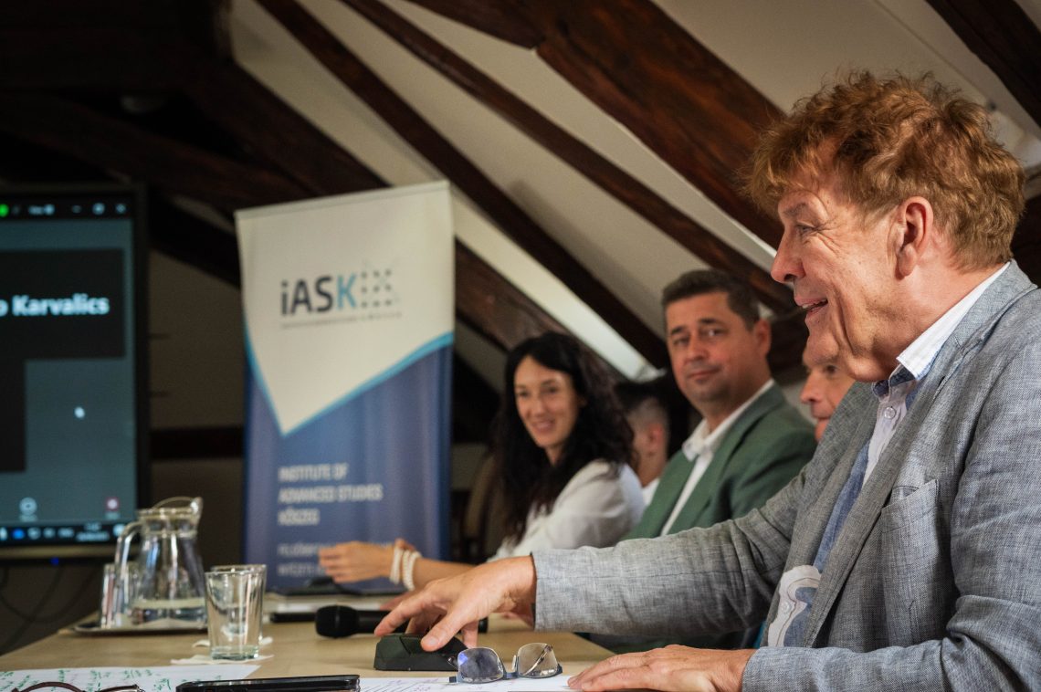 Üzleti megbeszélés az iASK logóval a háttérben.