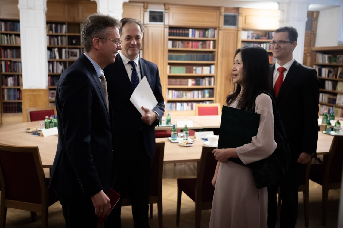 Egyezség Kőszegen: emberek tárgyalnak egy könyvtárszobában, az ENSZ Egyetem új intézetének alapításáról.