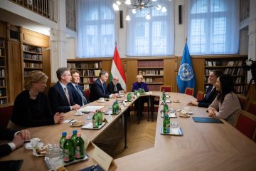 Tárgyalóterem, asztalnál ülő emberek, magyar és ENSZ zászló. Új ENSZ Egyetem intézet Kőszegen.