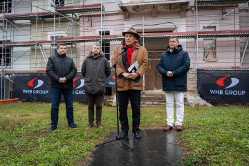 Kőszeg: Férfiak az ENSZ Egyetem új Campusának építkezésénél. WHB Group logó.