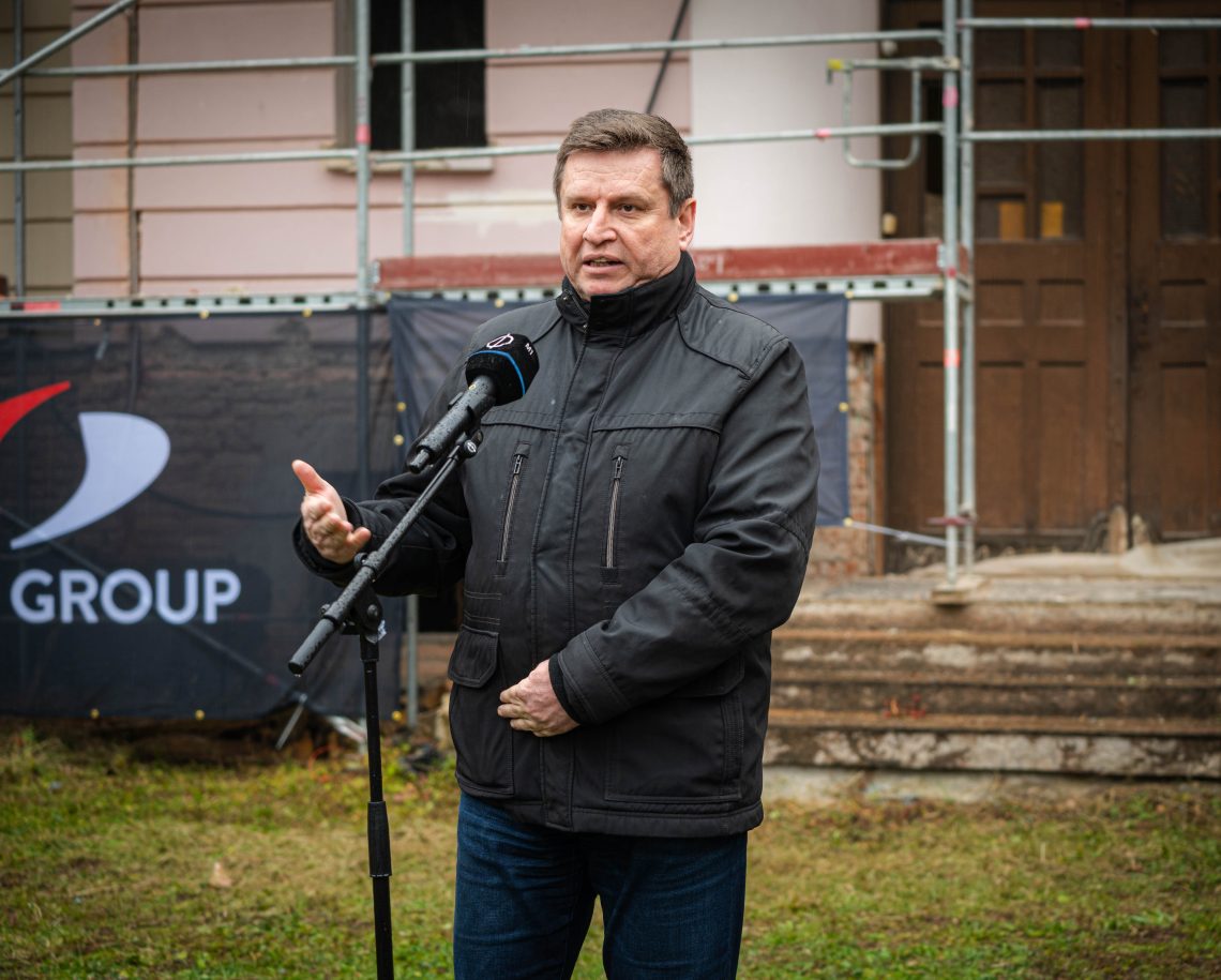 Férfi beszél mikrofonba a Kőszegen épülő Kutatási és Fejlesztési Központ előtt.