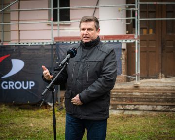 Férfi beszél mikrofonba a Kőszegen épülő Kutatási és Fejlesztési Központ előtt.