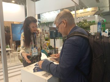 iASK a Smart City Expo Világkongresszuson: Nő beszélget egy férfival egy standnál.
