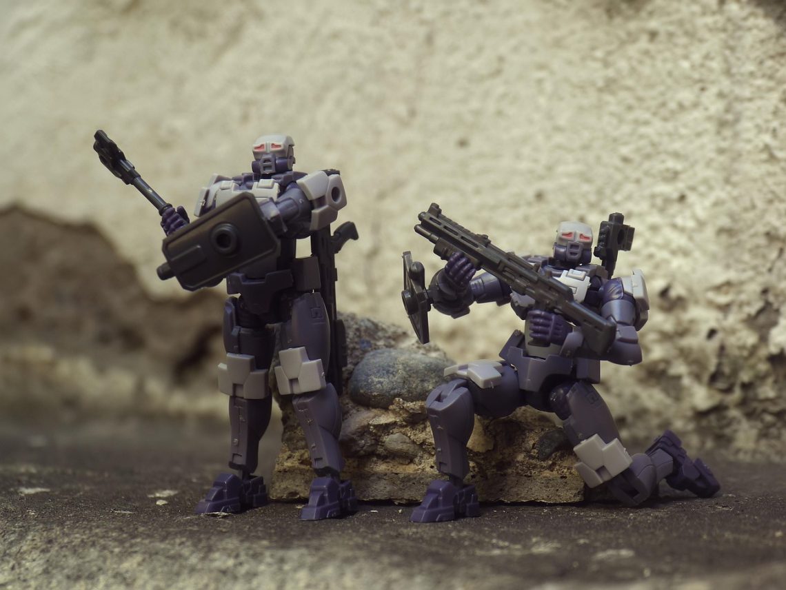 Két robotfigura fegyverekkel, a "Climate BioStress Sentinel System" témához kapcsolódóan.