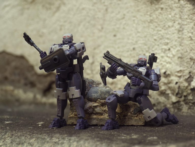 Két robotfigura fegyverekkel, a "Climate BioStress Sentinel System" témához kapcsolódóan.