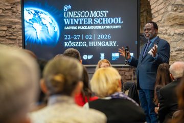 Tshilidzi Marwala előadást tart a UNESCO MOST Winter School rendezvényen Kőszegen. "Lasting Peace and Human Security" felirat olvasható.